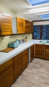 a kitchen with wooden cabinets and white counter tops at Y Fedw Wen in Bont Newydd