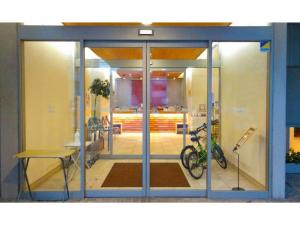 Una puerta de cristal de un edificio con una bicicleta dentro. en Smile Hotel Matsuyama - Vacation STAY 04478v, en Matsuyama