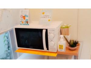 un horno microondas sentado en un estante en Smile Hotel Matsuyama - Vacation STAY 04478v, en Matsuyama