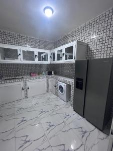 a kitchen with white cabinets and a washer and dryer at SKA Zac Mbao in Rufisque