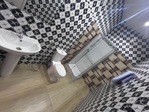 a bathroom with a sink and a toilet and a mirror at SKA Zac Mbao in Rufisque