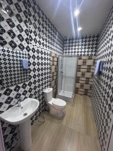 a bathroom with a toilet and a sink and a shower at SKA Zac Mbao in Rufisque