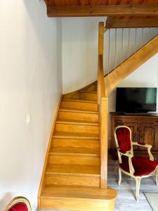 a staircase with a red chair and a television at Grande maison dans la nature in Le Port