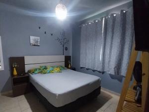 a bedroom with a white bed and a window at Verde Mar Abricó 2 in Rio das Ostras