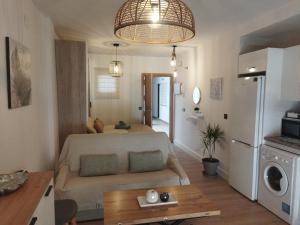 a small living room with a couch and a kitchen at Loft Claudia Portil in Punta Umbría