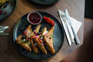 a black plate with food on a wooden table at Hotel Living 35 Suites by Growing Group in Medellín +38 photos