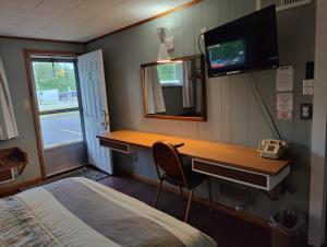 a bedroom with a desk and a bed and a phone at Melody Motor Lodge in Connellsville