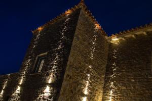 a tall building with lights on it at night at The Olive Yard in Gythio