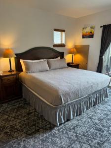 a bedroom with a large bed with two lamps and two tables at Morning Star Lodge - Hosted by Linda in Kellogg