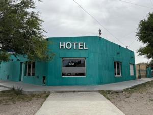 un edificio azul con las palabras hotel en él en La Posta de Adolfo, en Las Heras