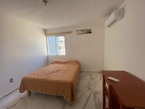 a small bedroom with a bed and a desk at Casa entera gran ubicación, aeropuerto ver in Veracruz