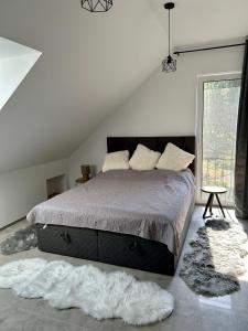 a bedroom with a large bed and a window at Strefa Natur dom z jacuzzi na wyłączność in Matyty