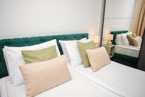 a group of pillows sitting on a bed in front of a mirror at Mak Apartment - free parking - balcony in Sarajevo +27 photos