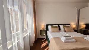 a bedroom with two beds and a large window at Mak Apartment - free parking - balcony in Sarajevo