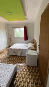 a bedroom with two beds and a green ceiling at Pousada Encontro dos Rios in Santa Bárbara +20 photos