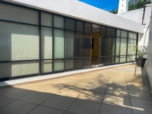 ein Gebäude mit Glasfenstern und einer Terrasse in der Unterkunft Casa Lomas de Cuernavaca in Jiutepec