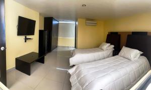 ein Hotelzimmer mit zwei Betten und einem Fernseher in der Unterkunft Casa Lomas de Cuernavaca in Jiutepec + 13 Fotos