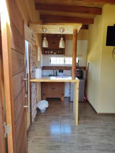 a kitchen with a wooden table in a room at Chalet Volga - Punta Del Diablo - Departamento de Rocha in Punta Del Diablo +45 photos