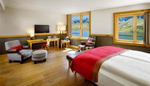 a hotel room with a bed and a desk and chairs at Frutt Mountain Resort in Frutt