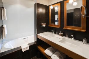 a bathroom with two sinks and a tub at Frutt Mountain Resort in Frutt