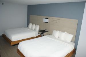 a hotel room with two beds with white sheets at Sonesta Essential Van Buren-Fort Smith in Van Buren