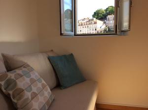 リスボンにあるBoavista appartement dans la Mourariaの窓のある部屋のソファ