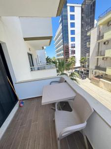 a balcony with a table and chairs on a building at Relax Apartment Qerret in Golem +2 photos