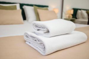 a pile of towels on a table in a bedroom at Mak Apartment - free parking - balcony in Sarajevo