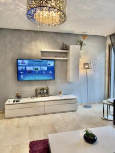 a living room with a large tv on the wall at Cozy & stylish apartment at Parc Prestigia in Fès