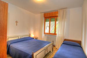 ein Schlafzimmer mit 2 Betten und einem Kreuz an der Wand in der Unterkunft Residence Villa Laura in Lignano Sabbiadoro