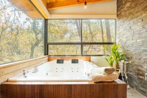 マサミトラにあるCabaña Mazamitla con Jacuzzi hasta para 5 personasの大きな窓のある客室で、大きなバスタブが備わります。 +16枚の写真