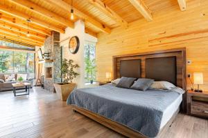 マサミトラにあるCabaña Mazamitla con Jacuzzi hasta para 5 personasの木製の部屋に大型ベッドが備わるベッドルーム1室が備わります。