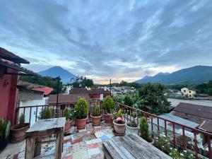 a balcony with a wooden table and potted plants at Jireh Antigua in Antigua Guatemala