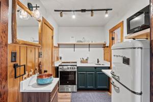 een keuken met groene kasten en een witte koelkast bij Timber Lodge #1 in Colorado Springs