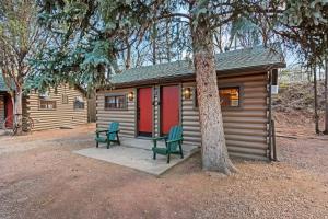 a cabin with two green chairs next to a tree at Timber Lodge #11 in Colorado Springs