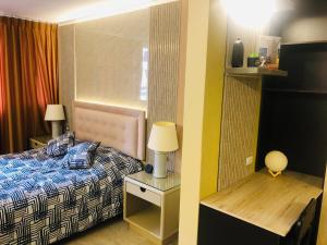 a bedroom with a bed and a table with a lamp at Luxurious Akros 526 Suite in Huamboya
