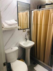 a bathroom with a toilet and a sink and a mirror at Luxurious Akros 526 Suite in Huamboya