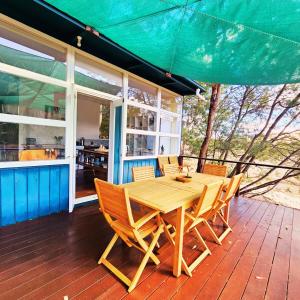 un tavolo e sedie in legno su una terrazza di legno di Sunrise Cottage 'Guildford VIC' a Guildford