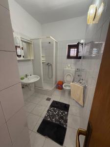 a white bathroom with a toilet and a sink at Apartments by the sea Kukljica, Ugljan - 8316 in Kukljica