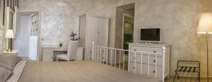 a bedroom with a bed and a desk and a television at Relais La Pretura in Vieste