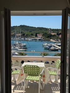 a table and chairs on a balcony with a view of a harbor at Apartments by the sea Kukljica, Ugljan - 8316 in Kukljica +25 photos