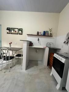eine Küche mit Theke, Tisch und Herd in der Unterkunft Flat Ivy ao lado da Avenida JK in Palmas + 32 Fotos