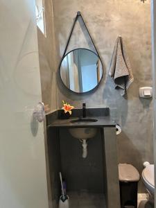 ein Badezimmer mit Waschbecken und Spiegel in der Unterkunft Flat Ivy ao lado da Avenida JK in Palmas