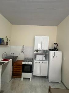 eine Küche mit einem weißen Kühlschrank und einem Herd in der Unterkunft Flat Ivy ao lado da Avenida JK in Palmas