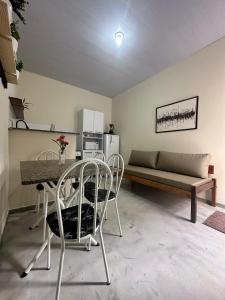 ein Wohnzimmer mit Tisch und Stühlen und einer Couch in der Unterkunft Flat Ivy ao lado da Avenida JK in Palmas