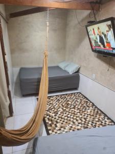 a hammock in a room with a tv at kitnet in Petrolina