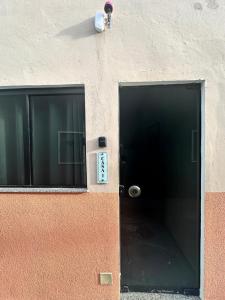 eine Tür zu einem Gebäude mit einem Fenster daneben in der Unterkunft Flat Ivy ao lado da Avenida JK in Palmas