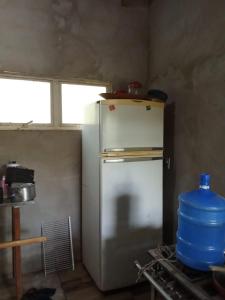 einen weißen Kühlschrank in einer Küche mit Fenster in der Unterkunft Pousada e pesqueiro Miko-in in Aquidauana