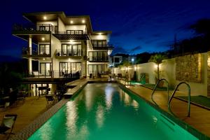 a house with a swimming pool at night at Ogma Suites Legazpi in Legazpi