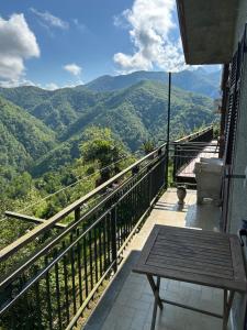 a balcony with a table and a view of mountains at Splendida vista in Marciaso